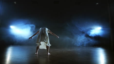 Mujer-Vestida-De-Blanco-En-El-Escenario-Con-Humo-Bailando-Ballet-Moderno.